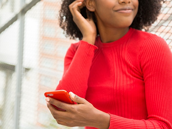 woman with red jumper on using phone